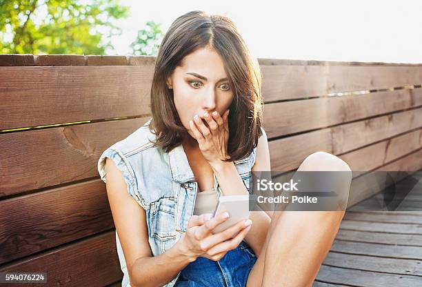 Surprised Girl Using Smart Phone Stock Photo - Download Image Now - Shock, Surprise, Women