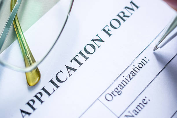 istock job application form on desk with pen and glasses 594076272