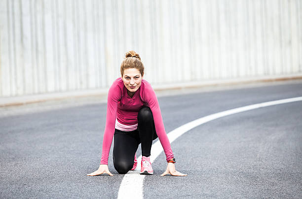 istock Female Runner Waiting in a Start Position on the Street 594445042