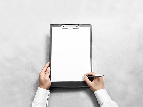 istock Hand signing blank black clipboard with white a4 paper design 594448562