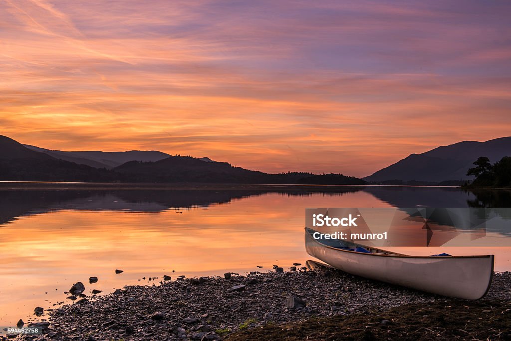 Canoe Sunset A canoe resting on Beach on Derwent Water in the English Lake District Derwent Water Stock Photo