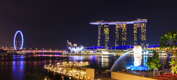 Artscience Museum and the Marina Bay Sands at night, an integrated resort fronting Marina Bay in Singapore. The complex includes three towers height 207 mt, topped by the Sands Skypark, a skyway connecting 340-metre-long large platform .