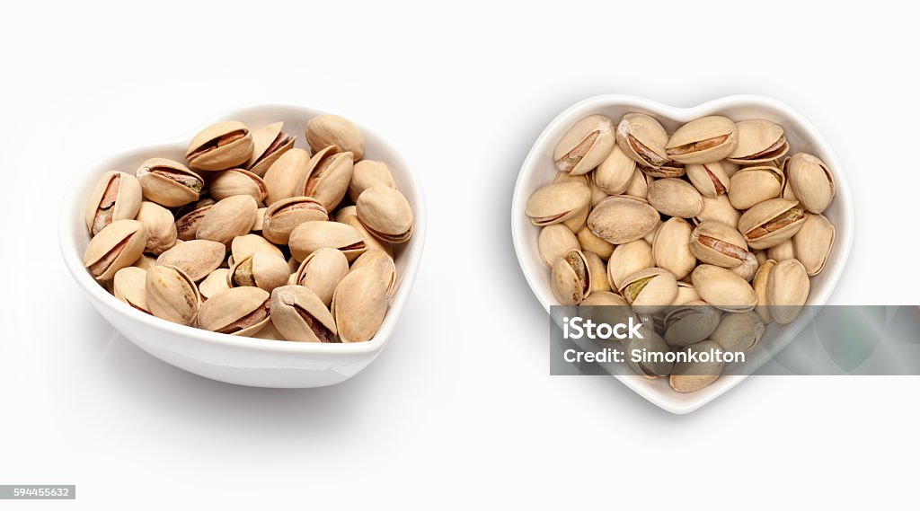 Pistachio in a heart shaped bowl Pistachio in a heart shaped bowl, isolated on white background Bowl Stock Photo