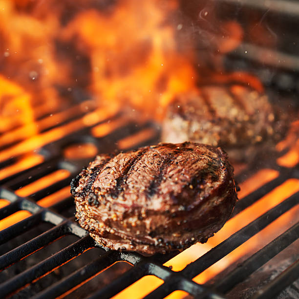 grilling filet mignon steaks on grill with flames - 免翁牛柳 個照片及圖片檔