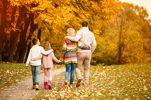 istock Family walking in autumn park 594461010