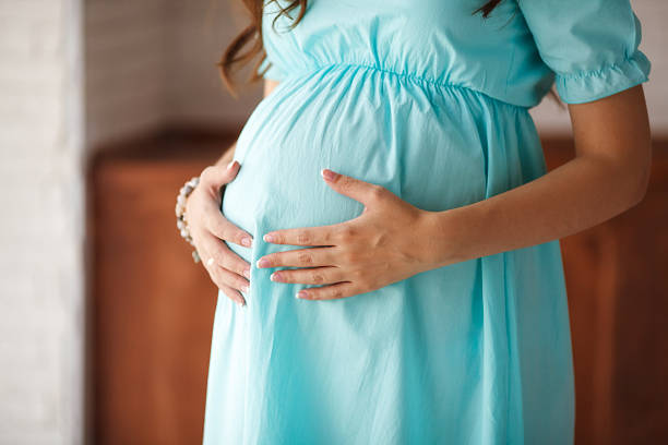istock Pregnant woman touching her belly with hands 594462756