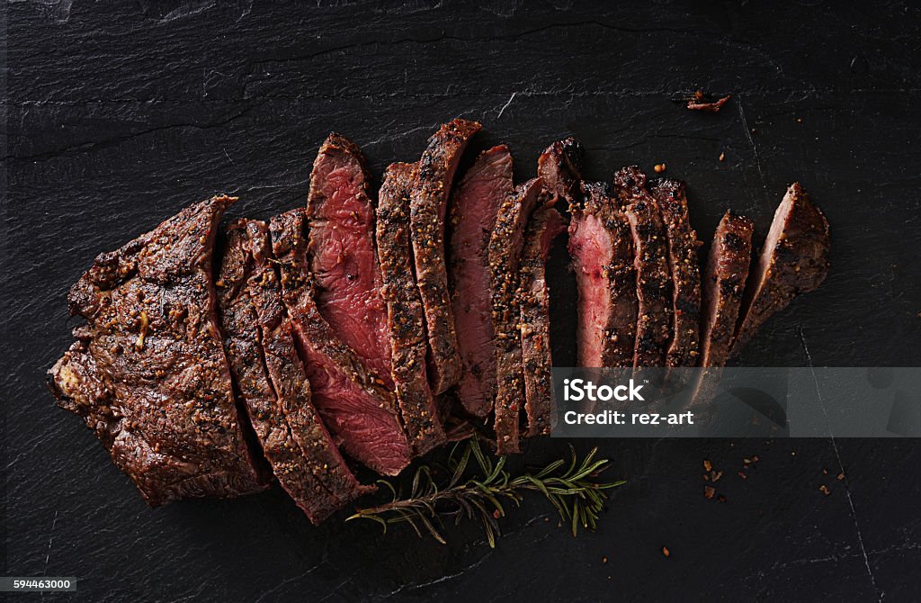 grilled flat iron steak shot in flat lay style grilled flat iron steak shot in flat lay style from overhead on dark slate Meat Stock Photo