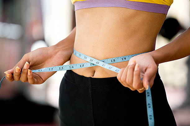 istock Woman measuring waist 594463456