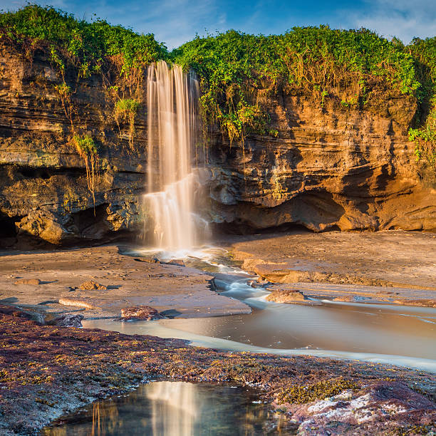 Beautiful waterfall near the beach at Melasti Beach Beautiful waterfall near the beach at Melasti Beach, Bali, Indonesia. tanah lot sunset stock pictures, royalty-free photos & images
