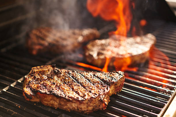 steki gotowanie na płonącym grillu - strip steak steak barbecue grill cooked zdjęcia i obrazy z banku zdjęć