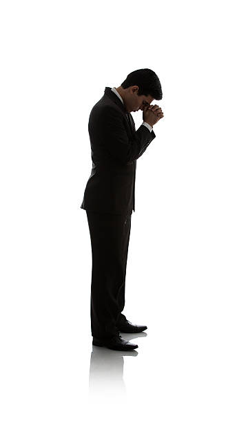 istock Side view of businessman standing and praying 594467280