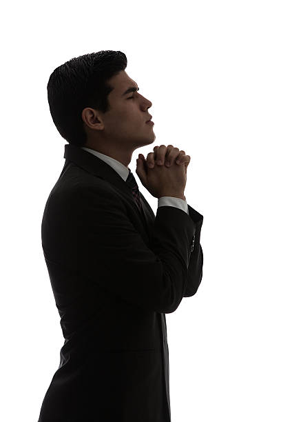 istock Young businessman praying head up and hands together 594467450