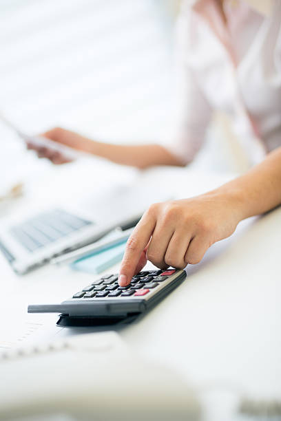 Hand of office worker using calculator stock photo