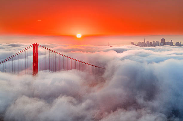 Golden Gate Bridge and Low Fog at sunrise Early morning fog blankets the Golden Gate, sunrise red the sky. san francisco bay stock pictures, royalty-free photos & images