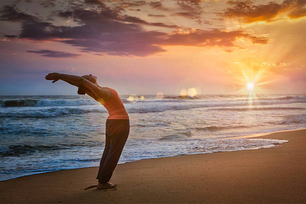 jovem homem de forma esportiva fazendo yoga sol saudação surya namaskar - saudação ao sol - fotografias e filmes do acervo