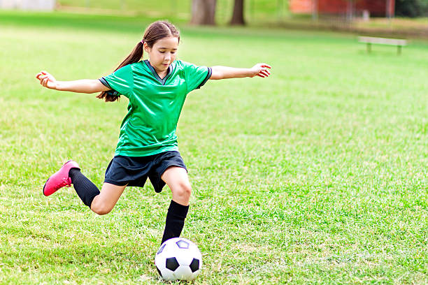 une préadolescente hispanique intense donne un coup de pied au ballon de football - soccer skill soccer ball kicking photos et images de collection