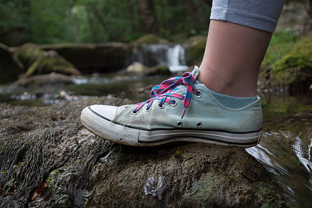 istock Girls foot stepping on a mossy rock 594475364