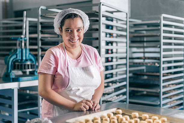 voluntario con discapacidad intelectual trabajando en taller de panadería - baking lifestyles beautiful cookie fotografías e imágenes de stock