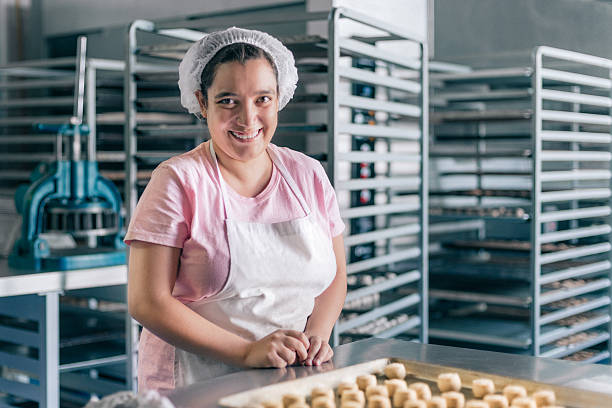 ベーカリーワークショップで働く非常食障害を持つボランティア - hat women chef occupation ストックフォトと画像