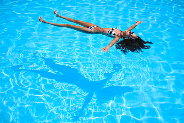 istock Girl floating in the pool 594476848