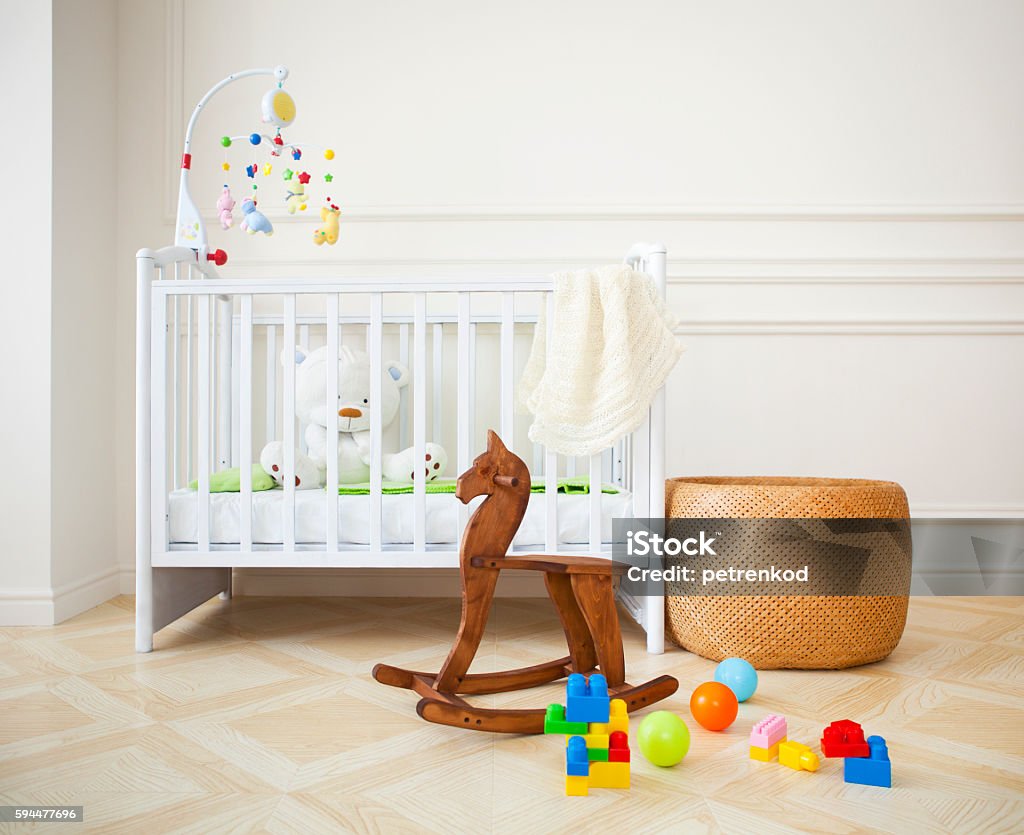 Empty cozy nursery room in light tones Empty nursery room with basket, toys and wooden horse Nursery - Bedroom Stock Photo