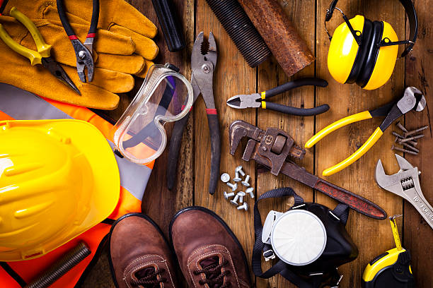 istock Personal safety workwear and tools border on rustic wood background 594480302