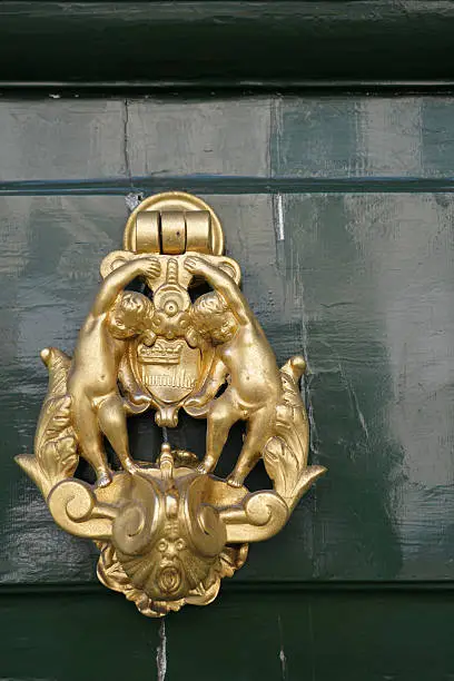 brass doorknocker at an old green door