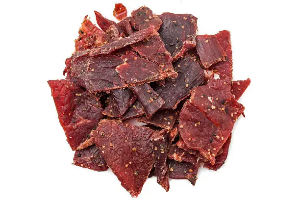 Heap of peppered Beef Jerky on white background from above