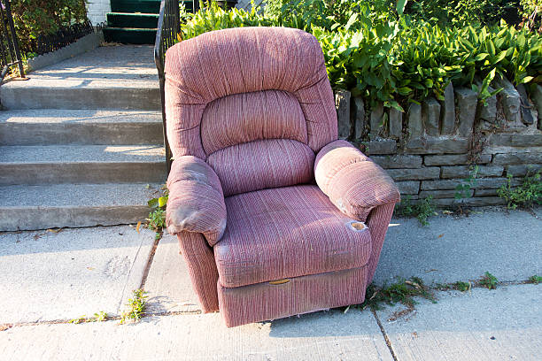 A chair left on the curb on garbage day to be thrown away.