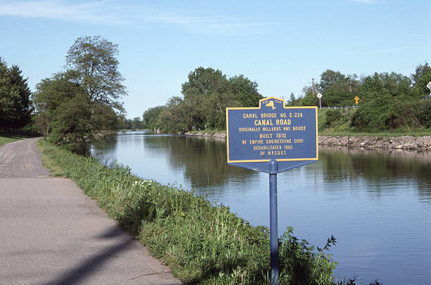 Erie Canal Erie Canal with historic bridge sign and towpath.  erie canal stock pictures, royalty-free photos & images