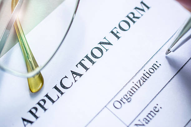 istock application form on desk with pen and glasses 594491126