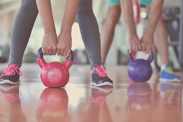 istock Kettlebells swing exercise man and woman workout at gym 594491618