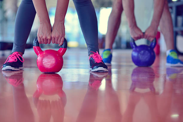 istock Kettlebells swing exercise man and woman workout at gym 594491666