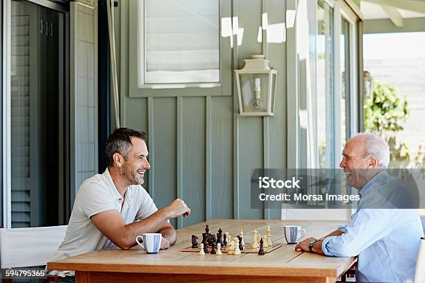 Smiling Senior Man Playing Chess With Son Stock Photo - Download Image Now - Chess, Playing, Adult