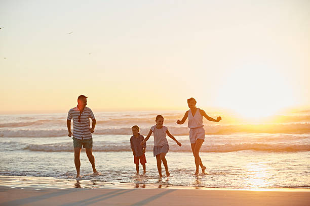 happy family running on shore - ankle deep in water photos et images de collection