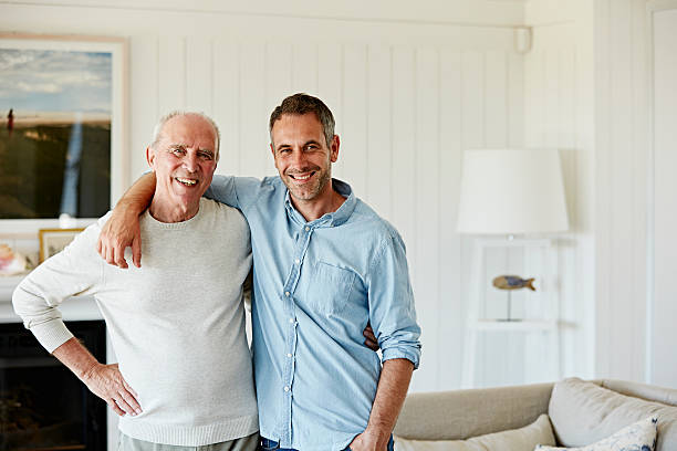 Portrait of smiling father and son at home Portrait of smiling father and son standing arm around at home short hair photos stock pictures, royalty-free photos & images