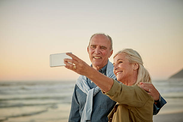 happy senior couple talking selfie on beach - 3097 - fotografias e filmes do acervo