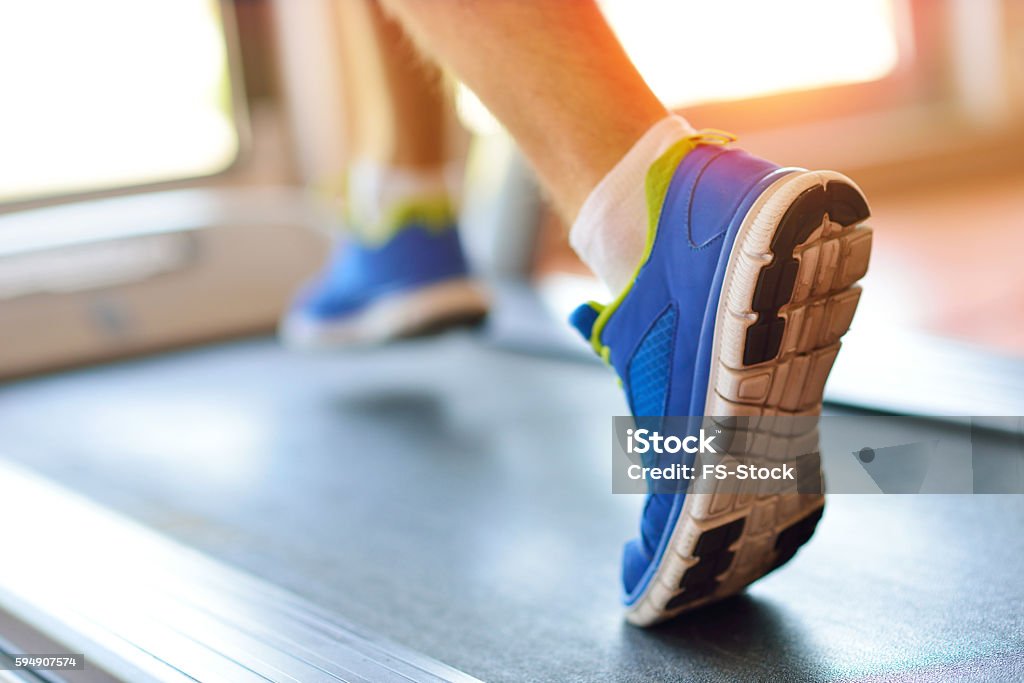 Man running in a gym on a treadmill Man running in a gym on a treadmill concept for exercising, fitness and healthy lifestyle Treadmill Stock Photo