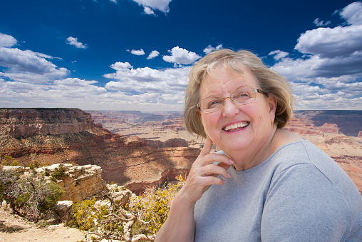 Happy Senior Woman Posing on the Edge of The Grand Canyon.