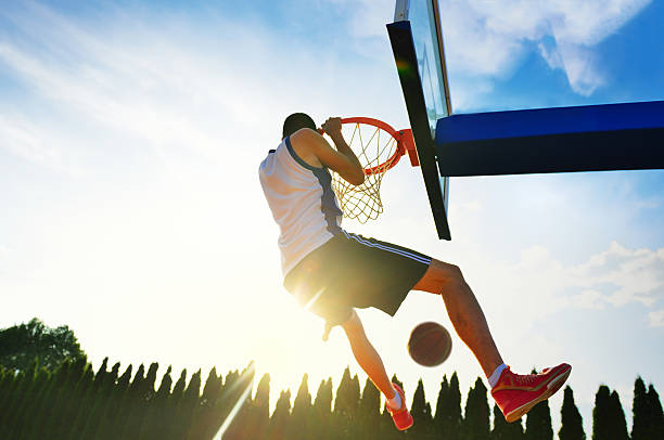 istock Street basketball player performing power slum dunk. 594912814