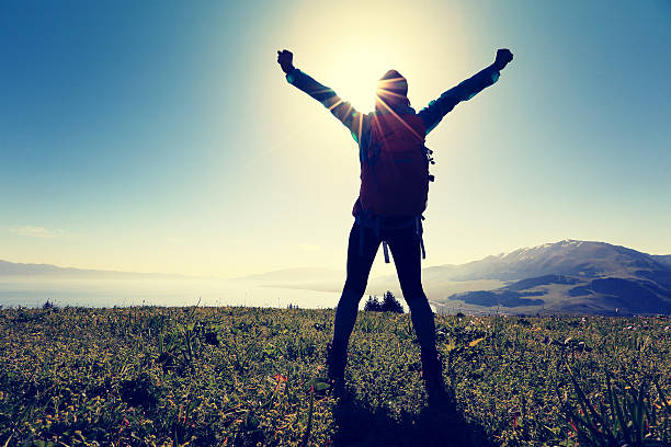 istock cheering successful woman backpacker open arms on mountain peak 594914060