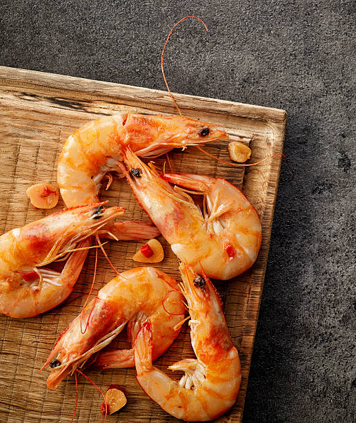 istock roasted prawns on wooden cutting board 594914122
