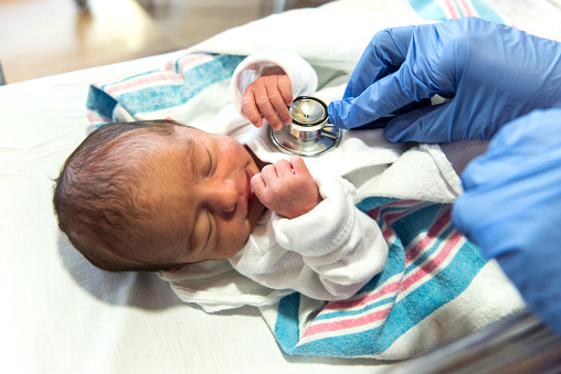 Doctor checking a newborn baby with an stethoscope