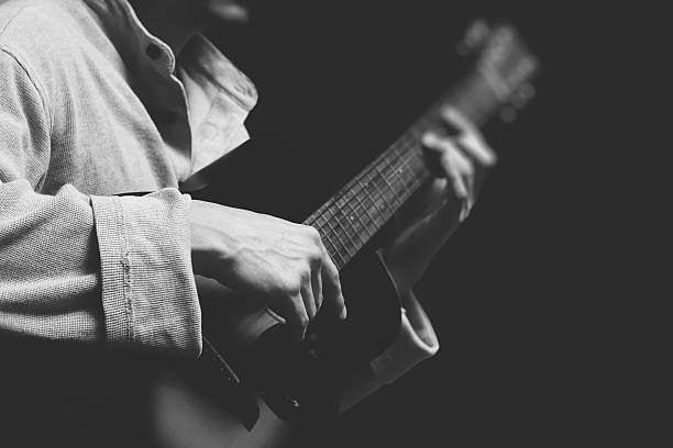 istock musician playing acoustic guitar, isolated on black 594916184