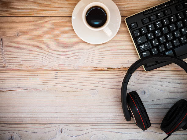 istock Office table with keyboard, headphones, cup of coffee. Top view 594917636