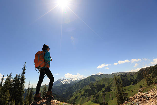 istock successful woman backpacker hiking on mountain peak 594918414