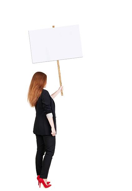 istock Back view business woman showing sign board. 594919316
