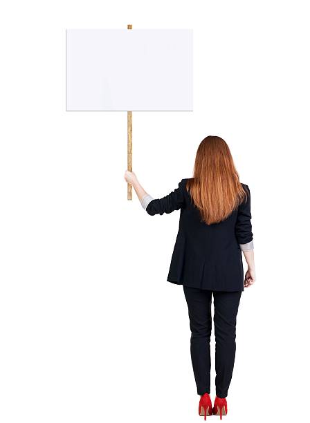 istock Back view business woman showing sign board. 594919550