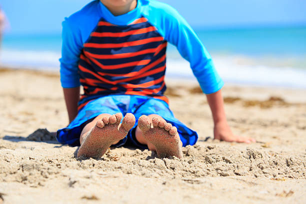 istock little boy relax at summer beach, focus on feet 594920818
