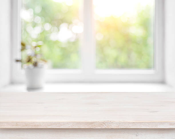 istock Wooden table on defocused summer window with flower pot background 594921228